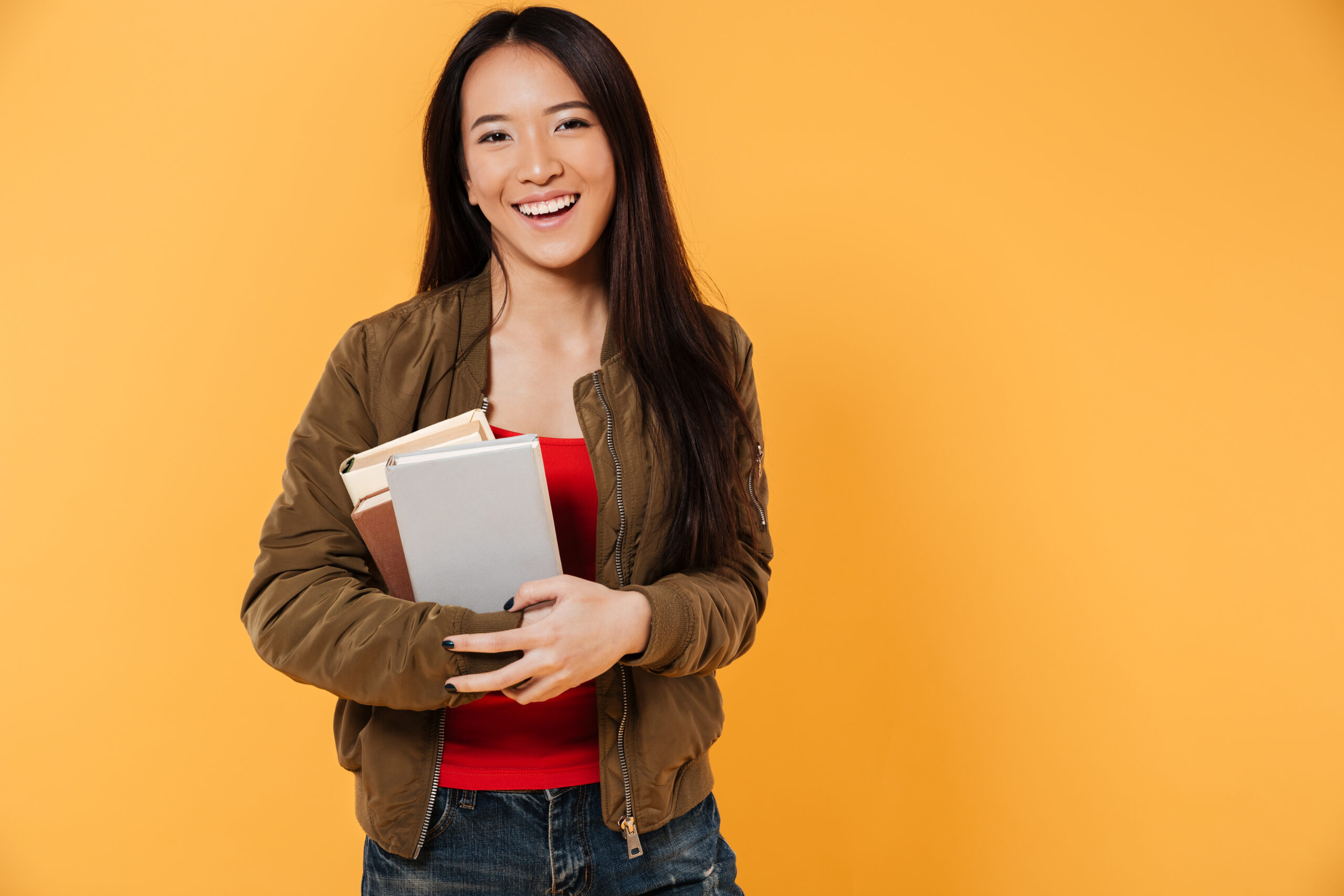 Portrait,Of,A,Happy,Pretty,Asian,Girl,Holding,Books,And